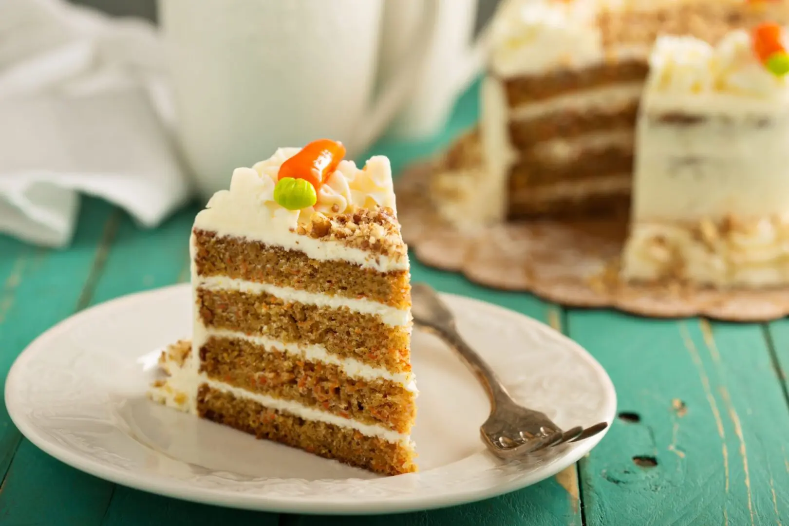 A slice of carrot cake on top of a white plate.
