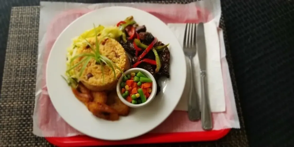 A plate of food on a tray with utensils.