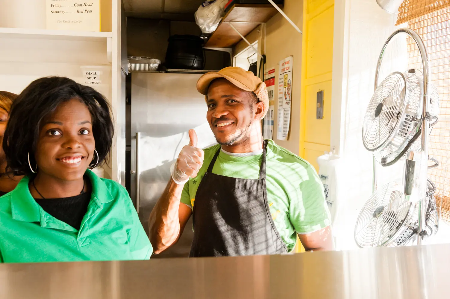 A man and woman in an apron smile for the camera.